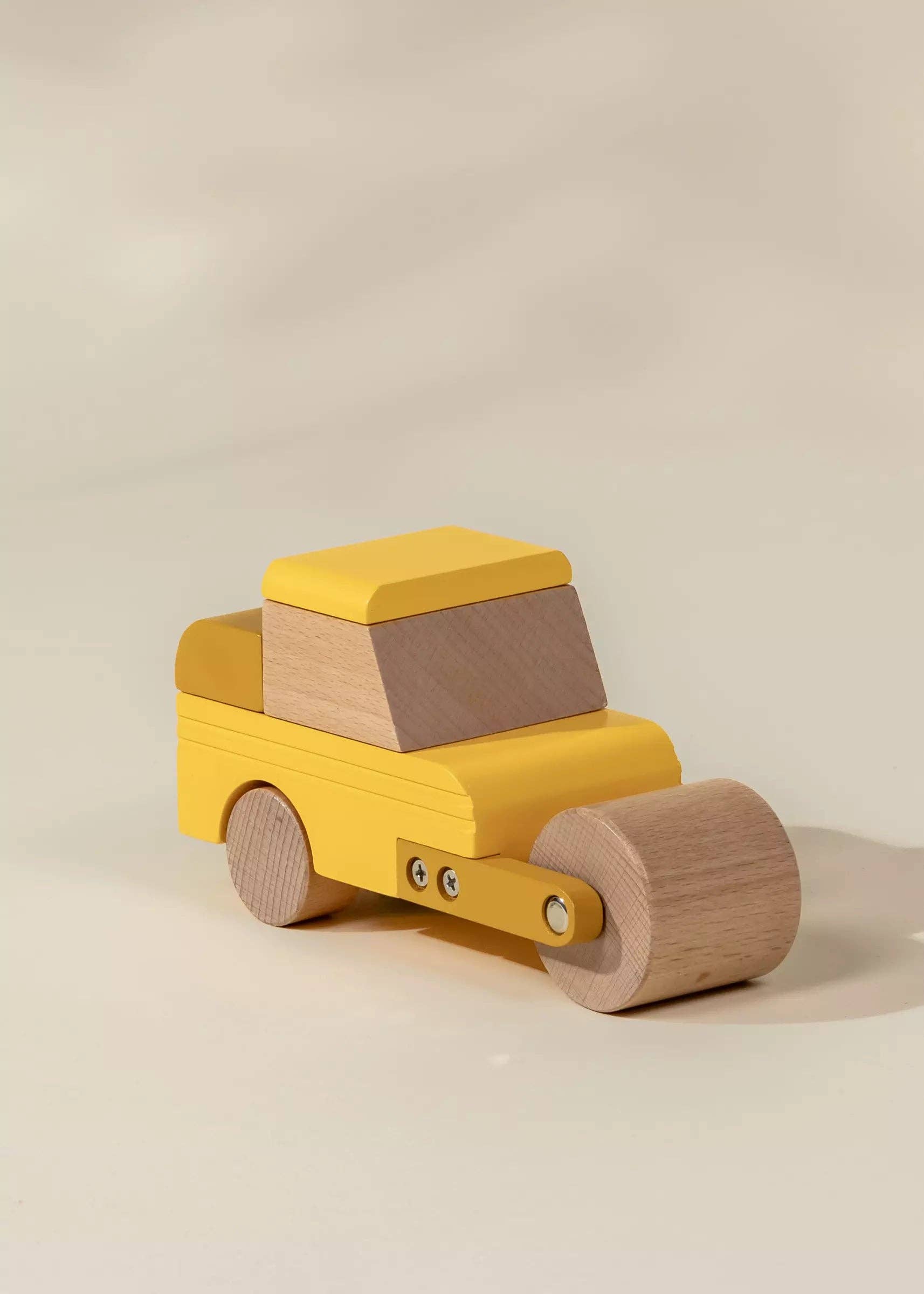 Wooden toy truck with a yellow body and brown wheels on a beige background
