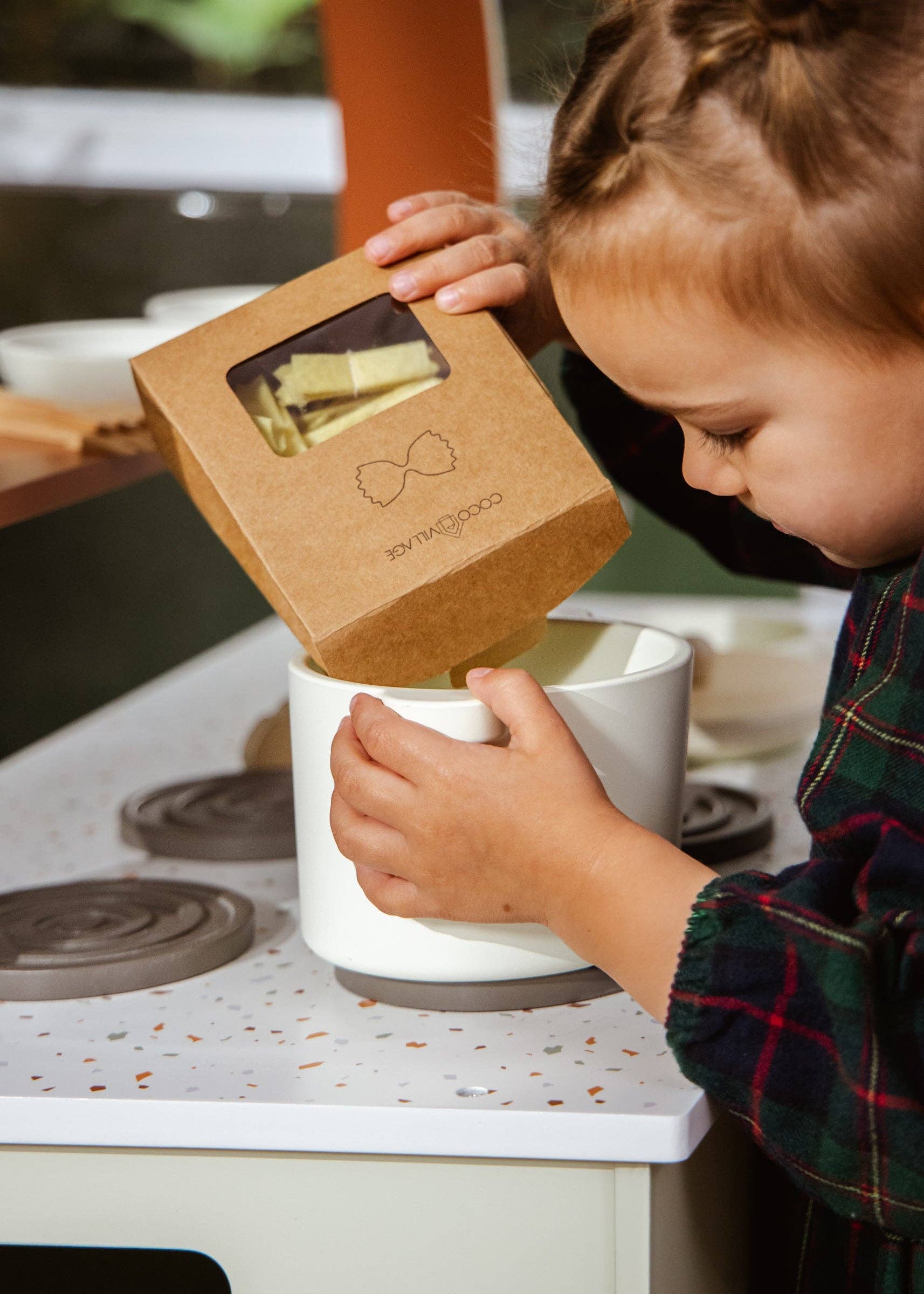 Child interacting with a kitchen appliance on a stove top