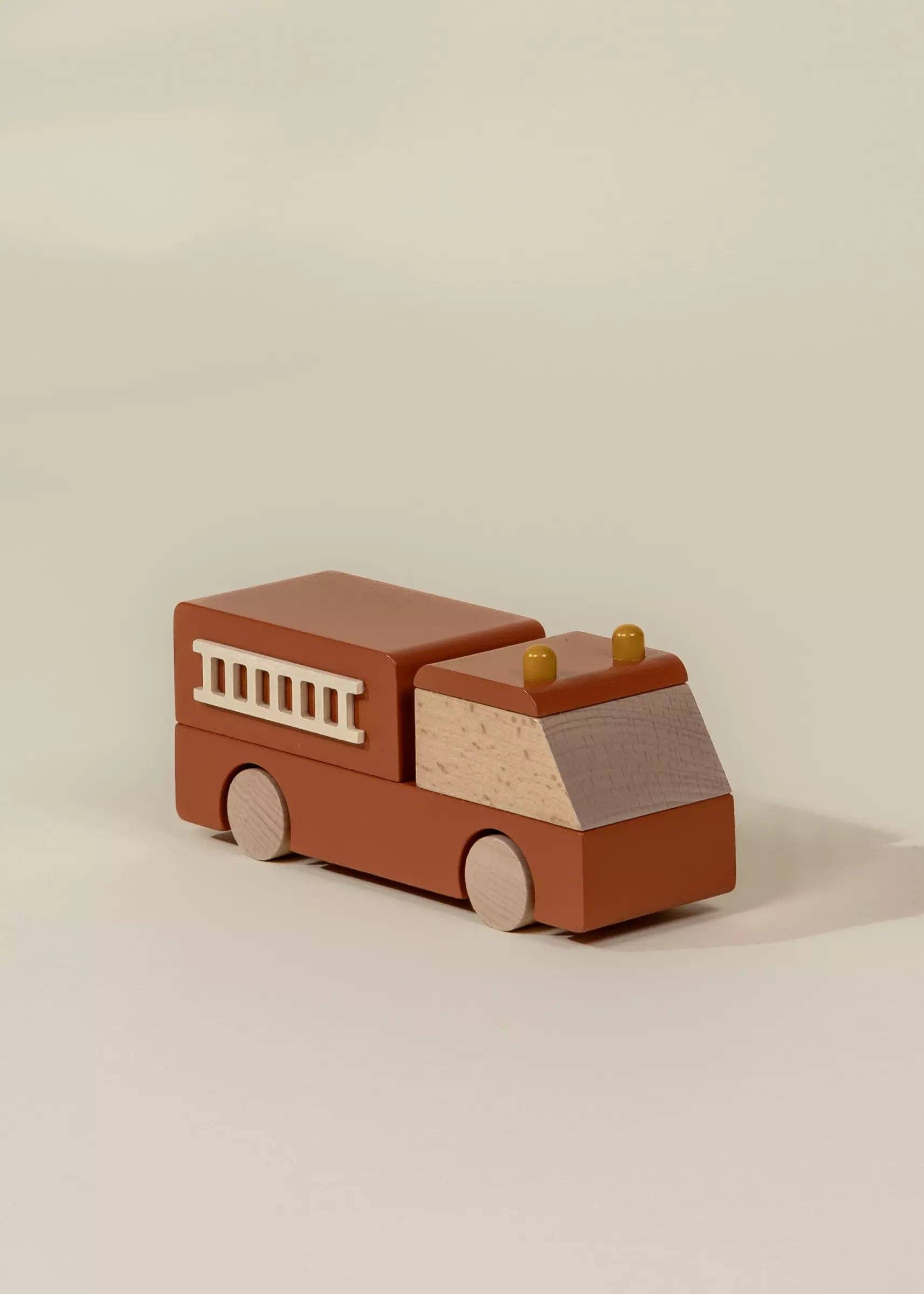 Wooden toy fire truck on a beige background