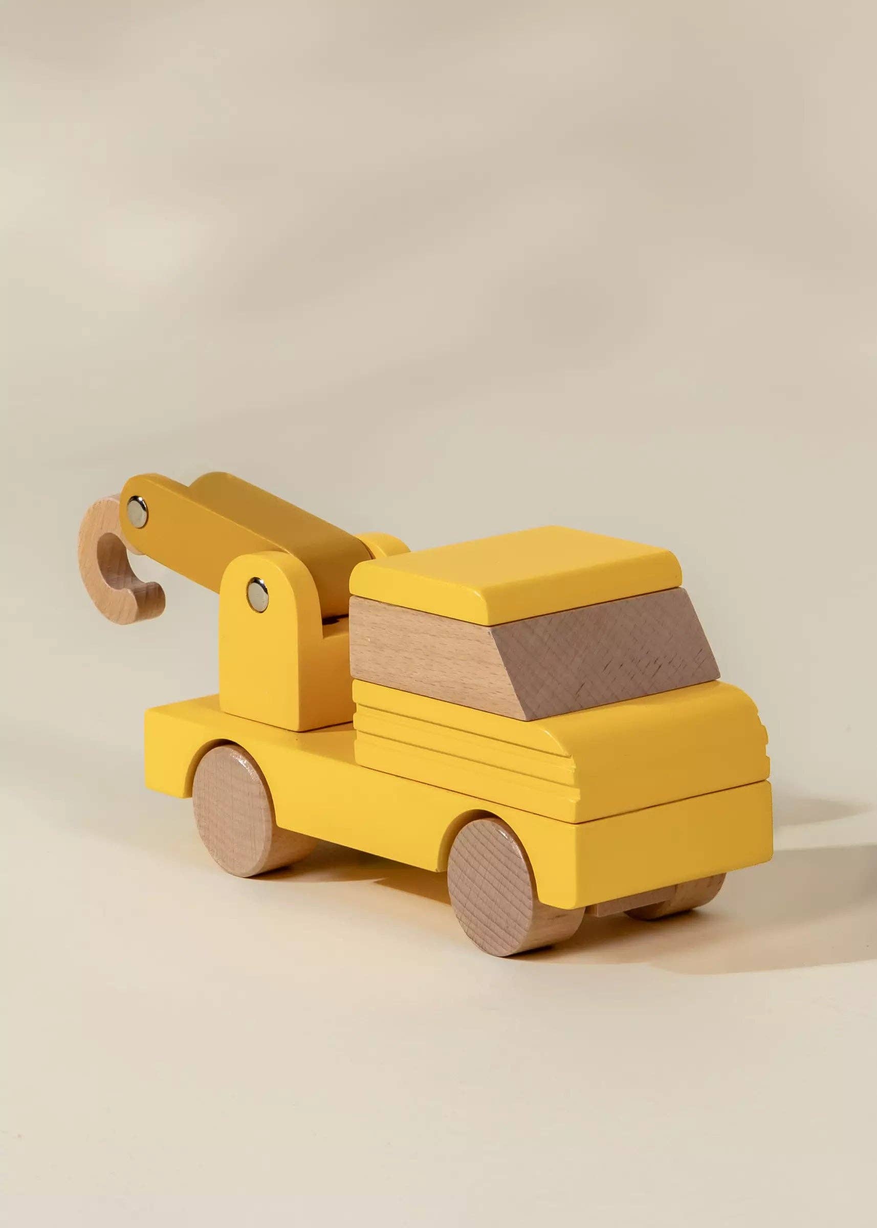 Yellow toy tow truck on a beige background