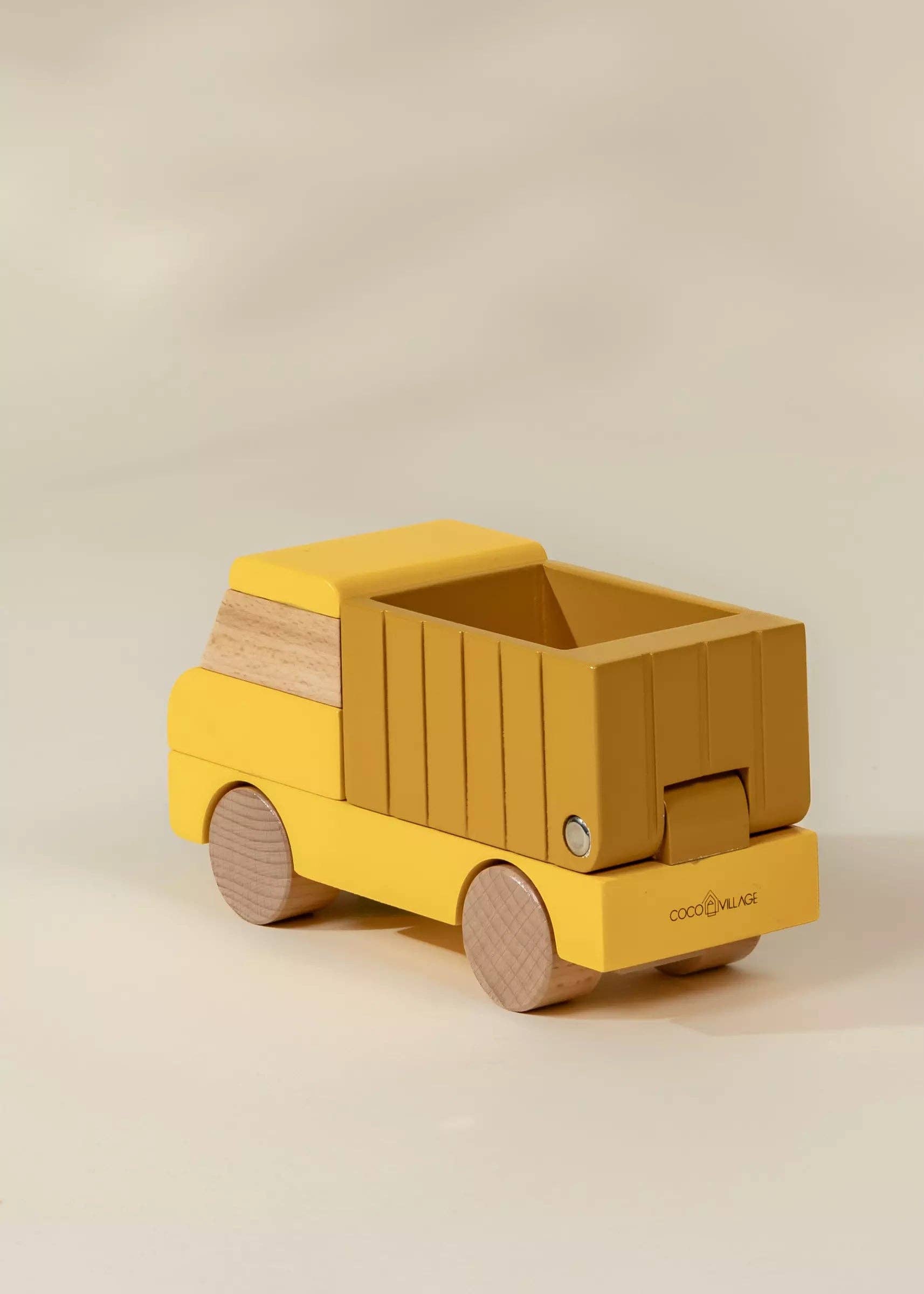 Yellow toy truck with wooden accents on a beige background