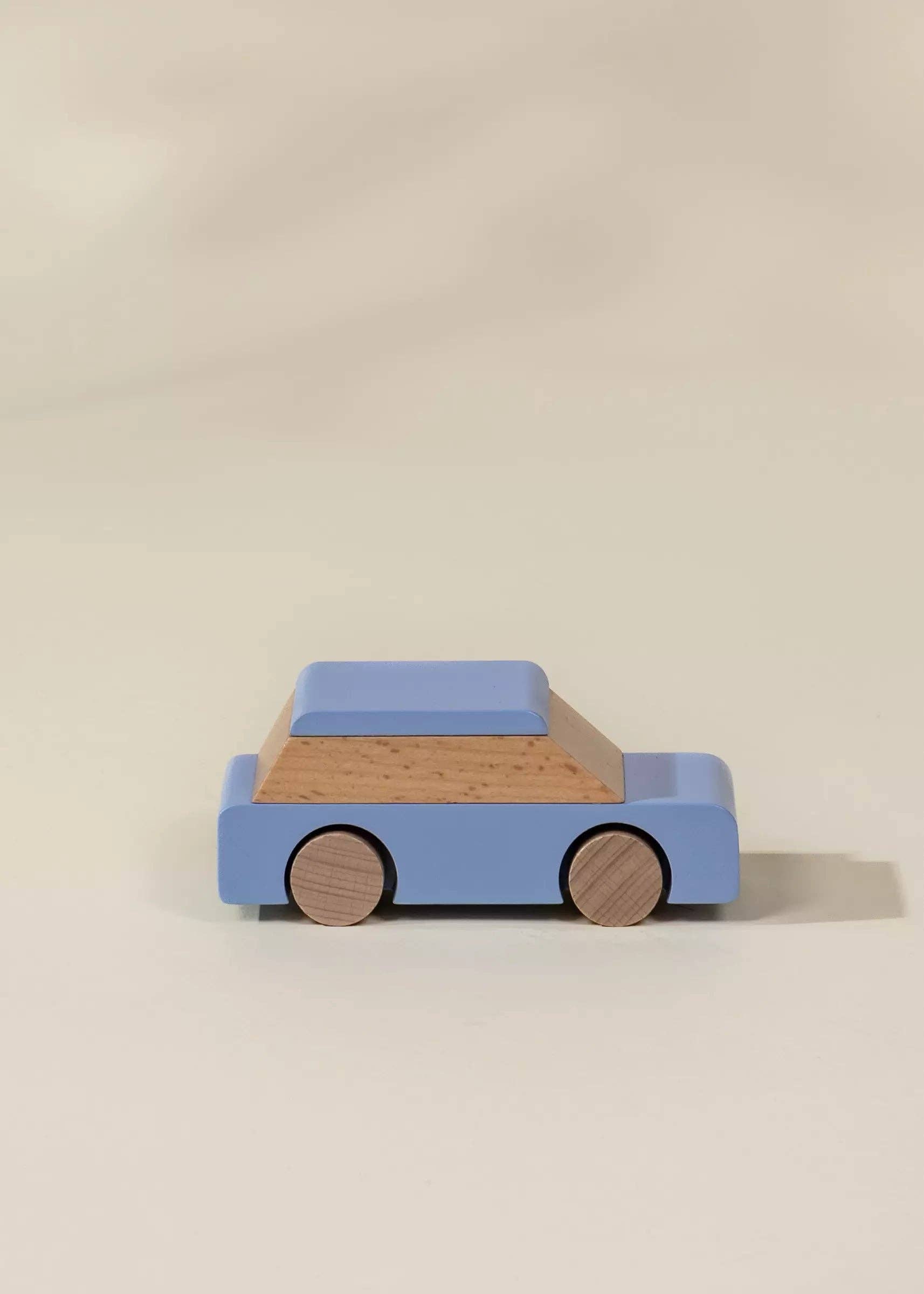 Wooden toy car with blue body and brown wheels on a beige background