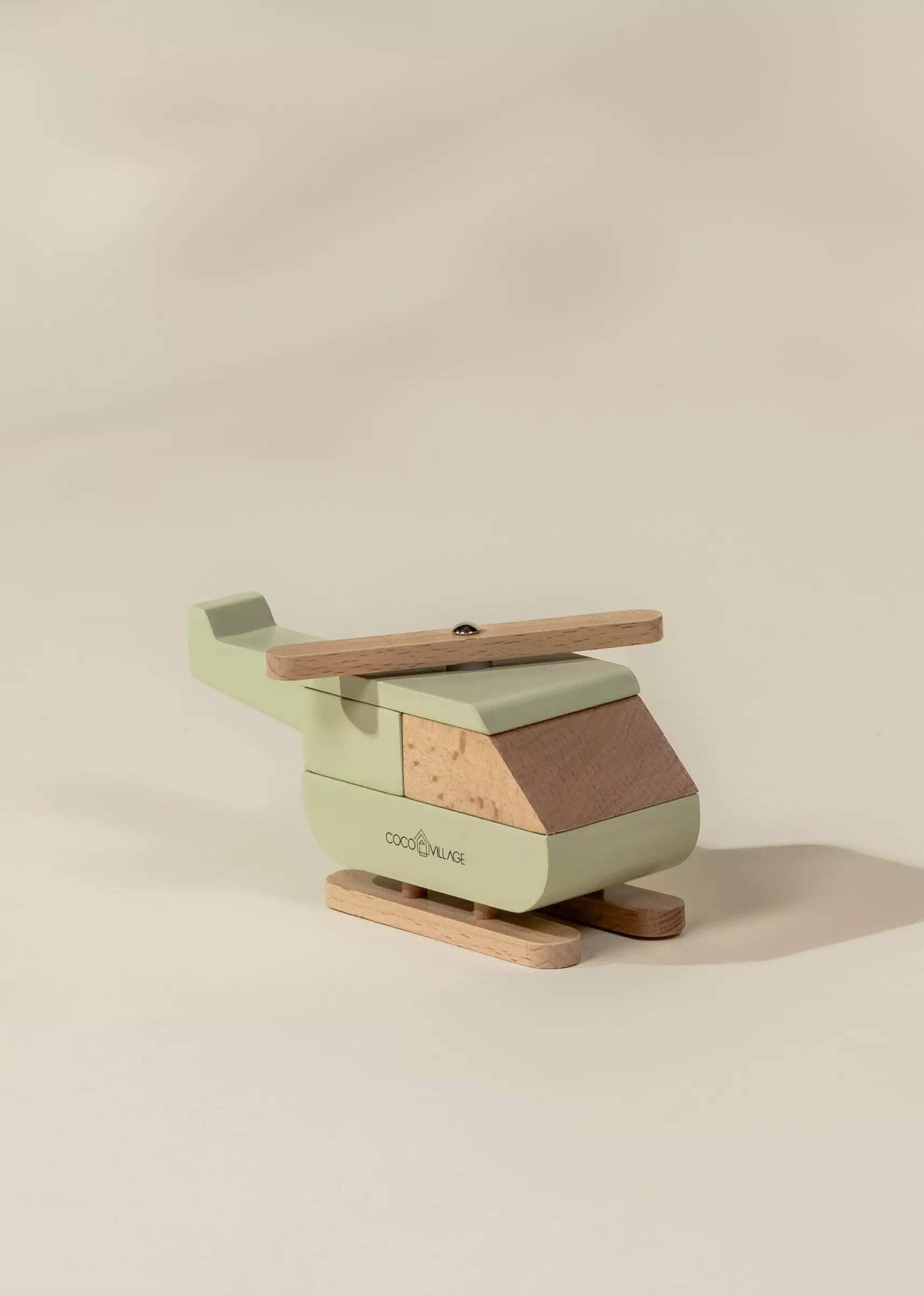 Green and brown wooden toy helicopter on a beige background