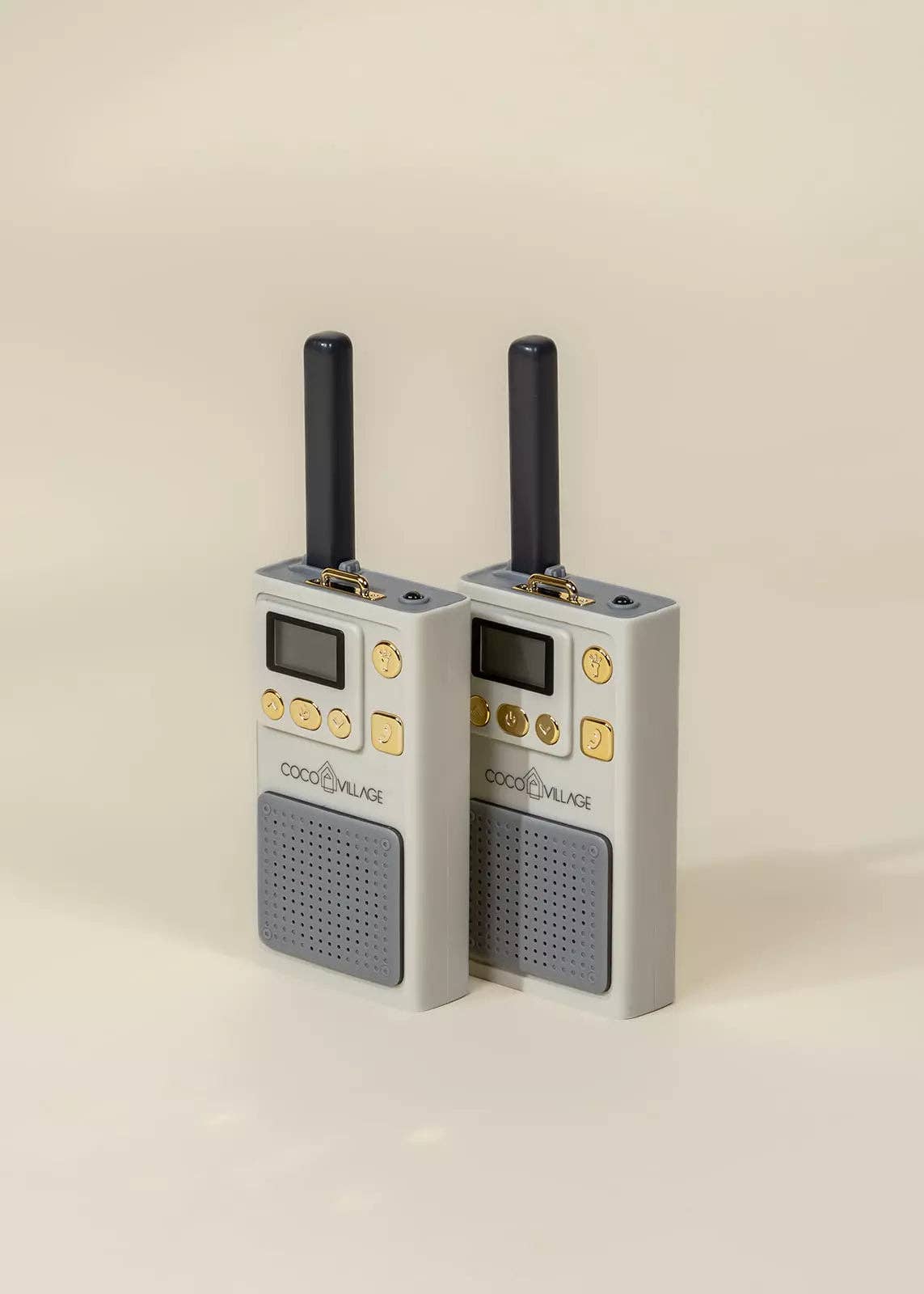 Two gray walkie-talkies with antennas on a beige background