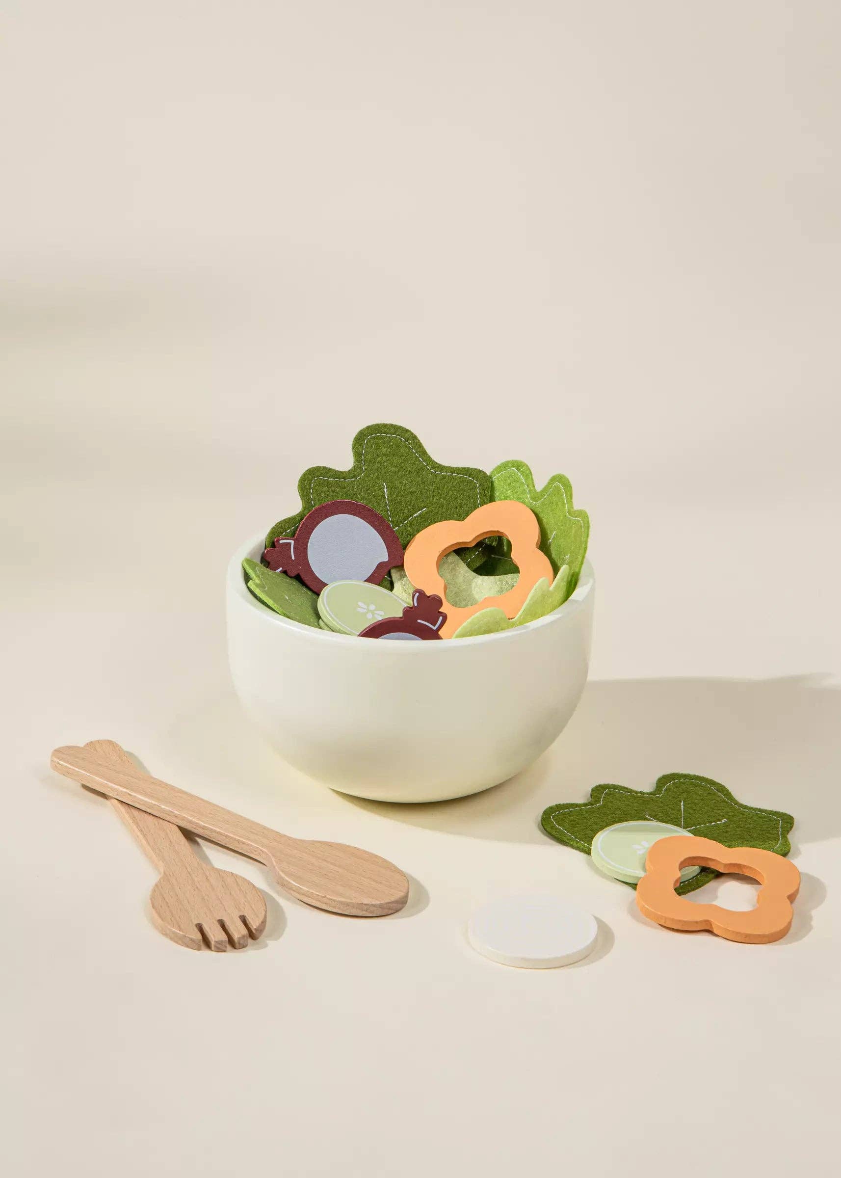 Children's toy set with leaf-shaped pieces and wooden utensils on a light background