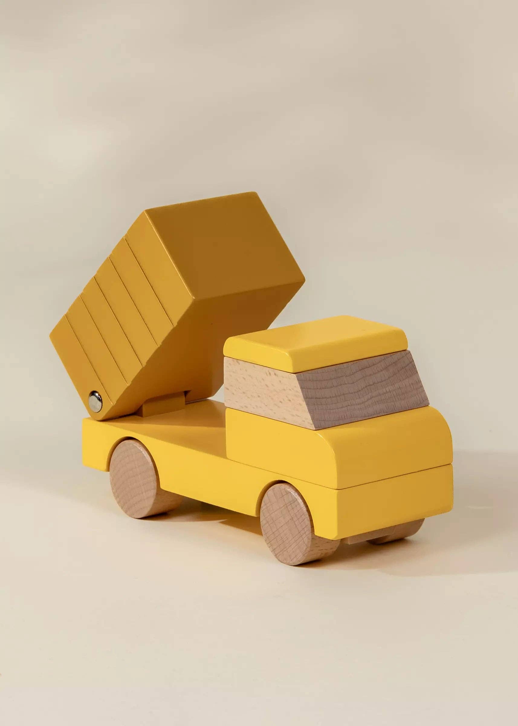 Yellow toy truck with an open cargo box on a beige background