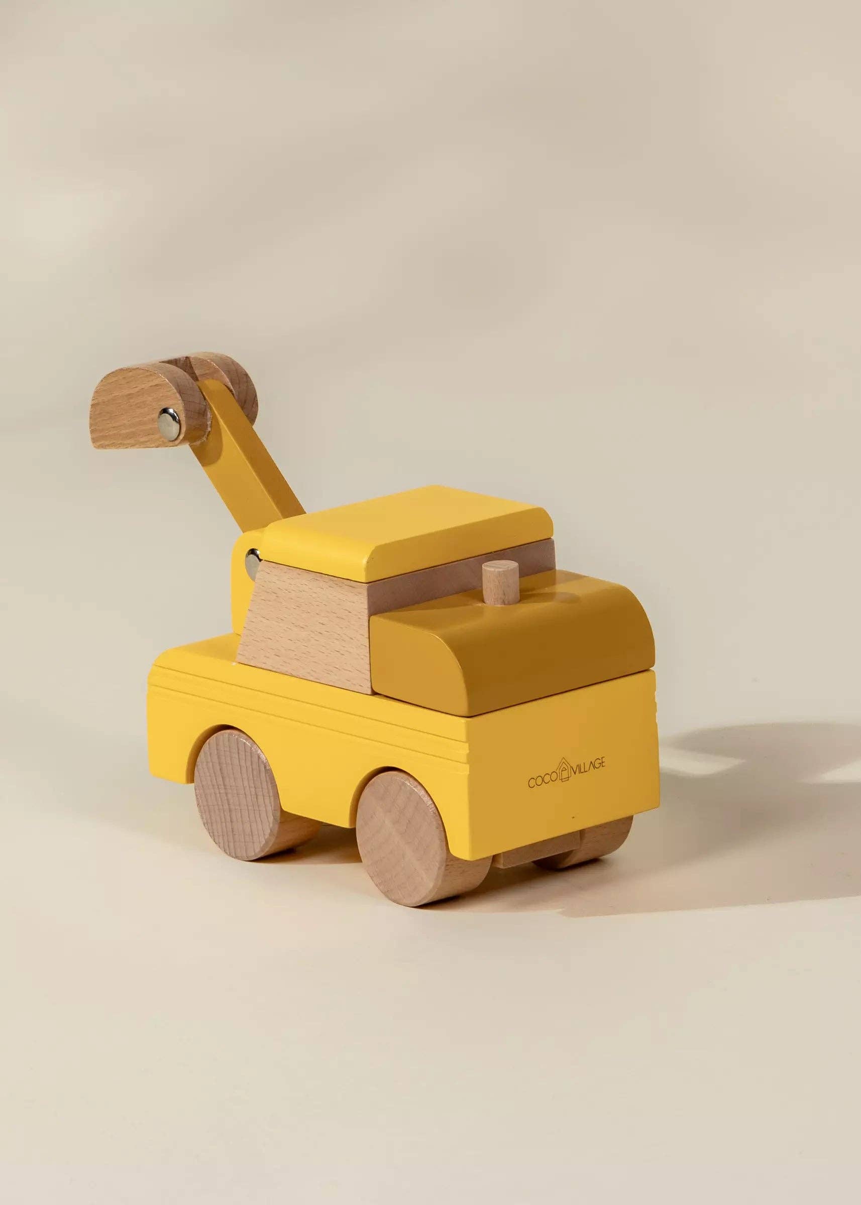 Yellow toy truck with wooden accents on a beige background