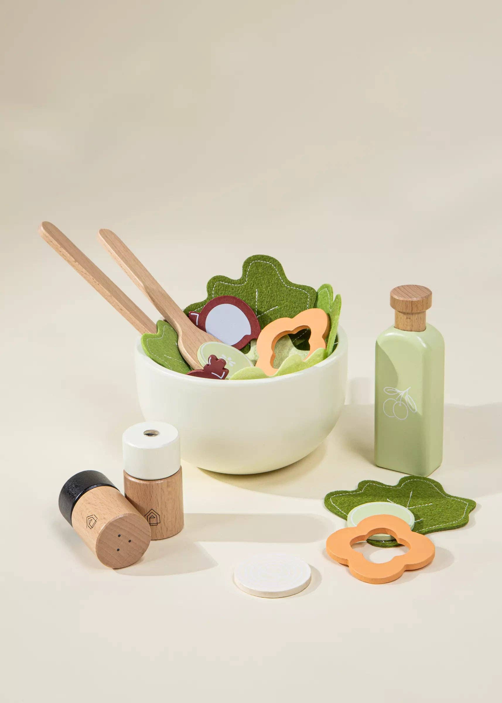 Set of wooden toys resembling kitchen items and a bottle on a light background