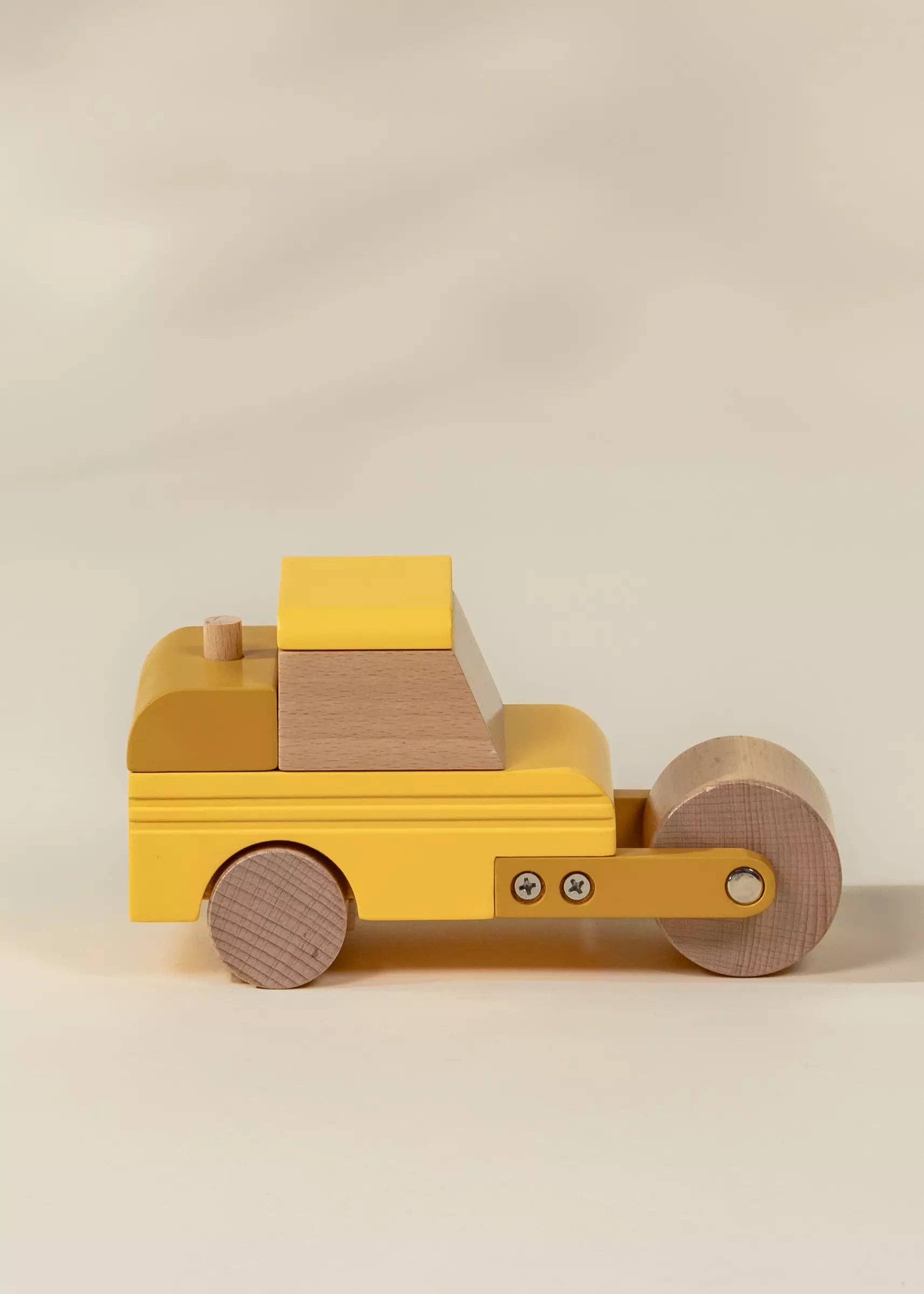 Wooden toy truck with a yellow cab and brown body on a beige background