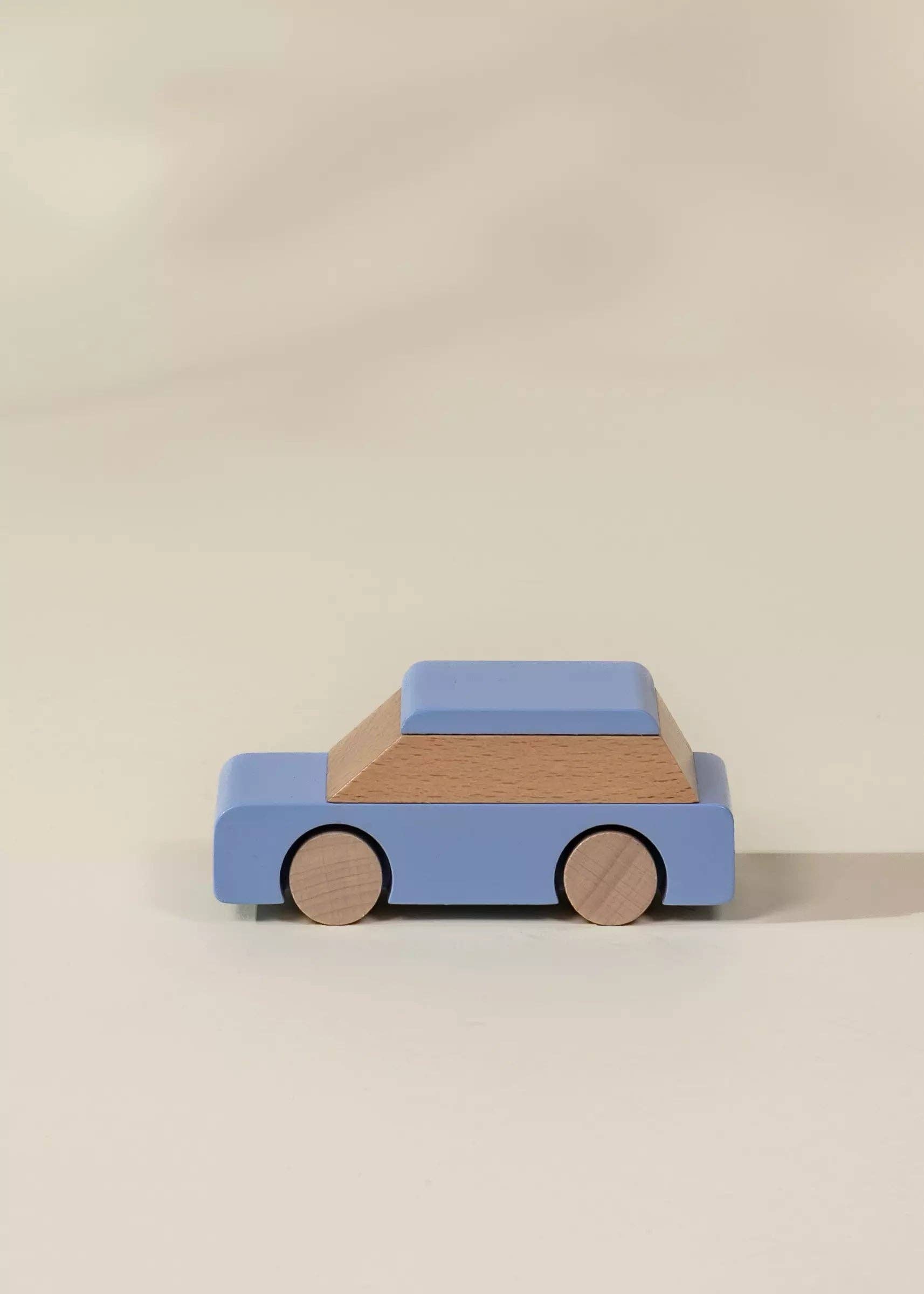 Wooden toy car with a blue body and brown roof on a beige background