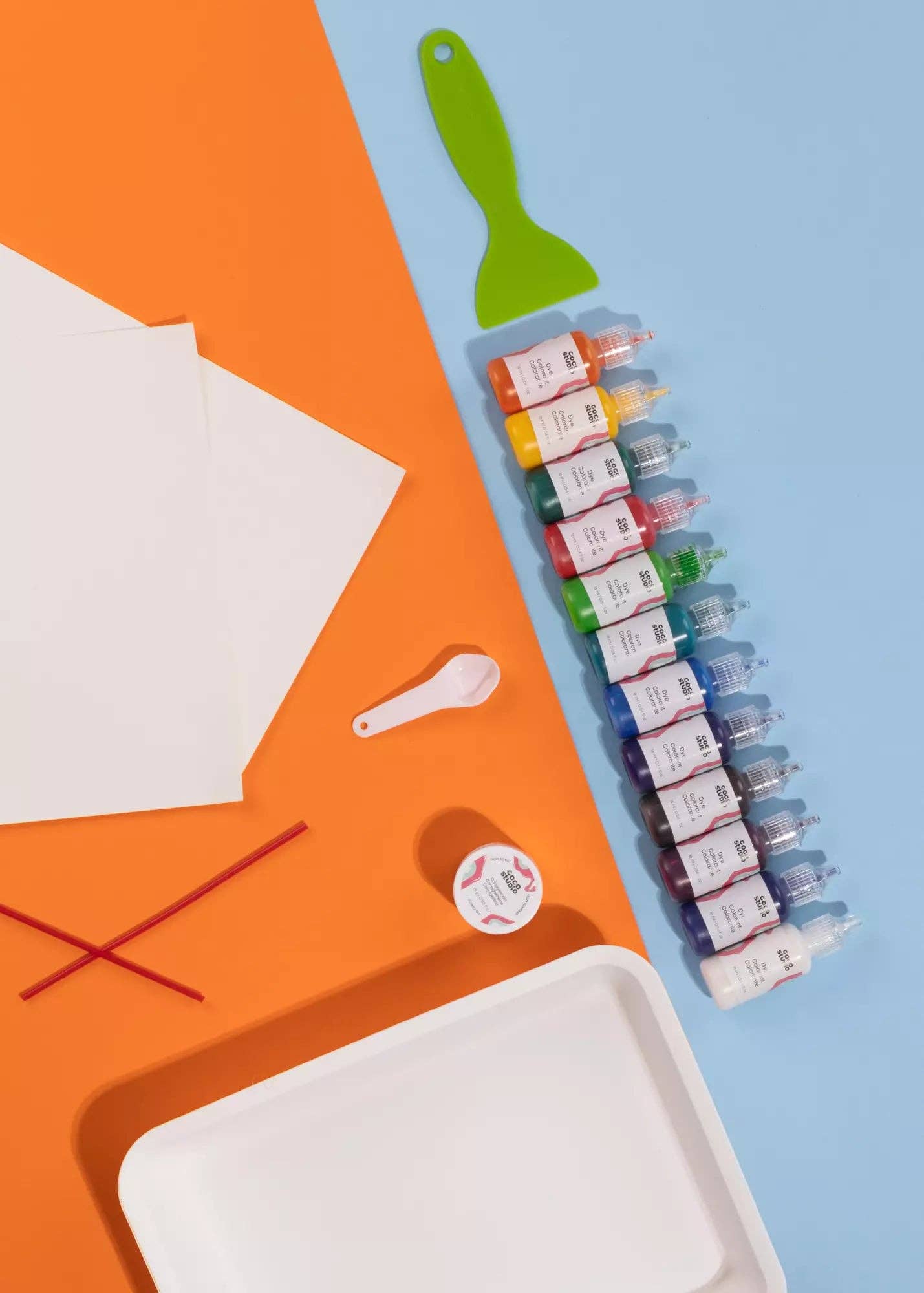 Set of ink bottles on a blue and orange background with paper and a brush.