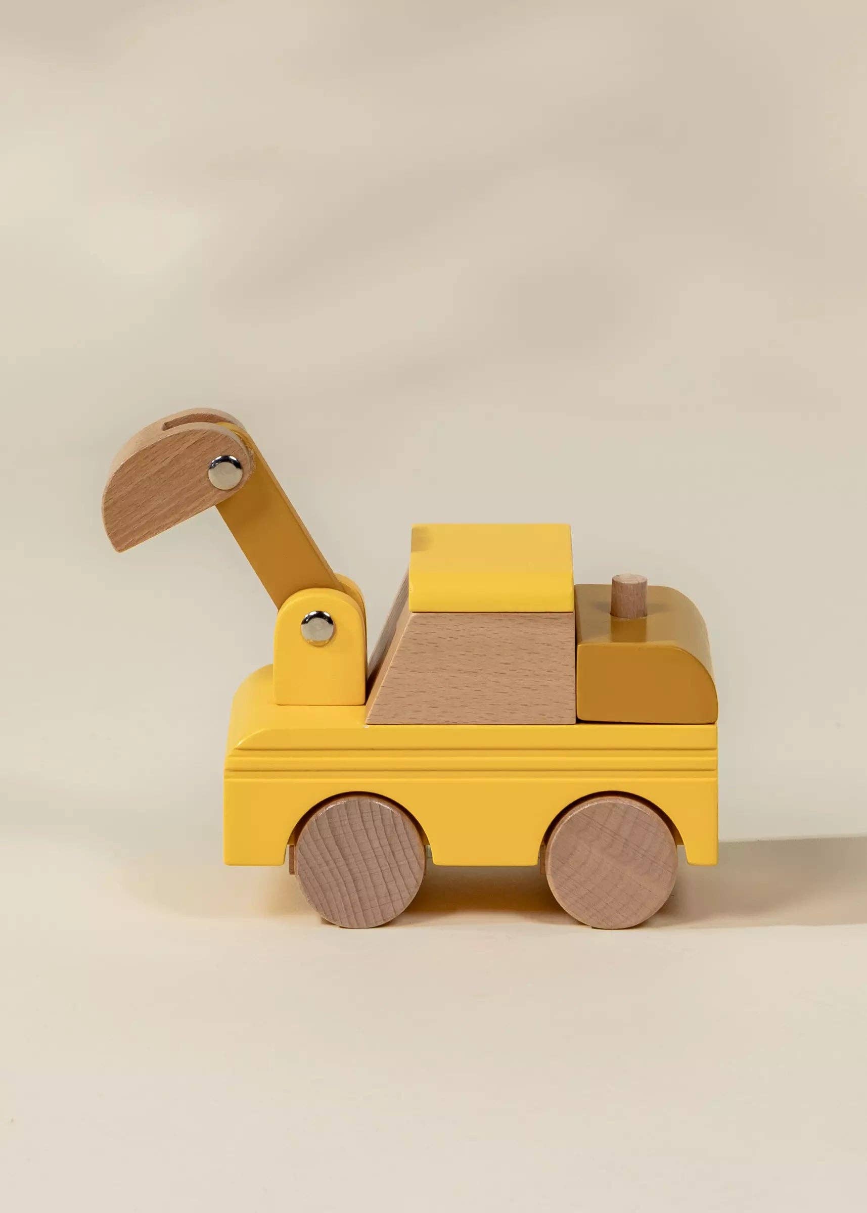 Wooden toy bulldozer on a beige background