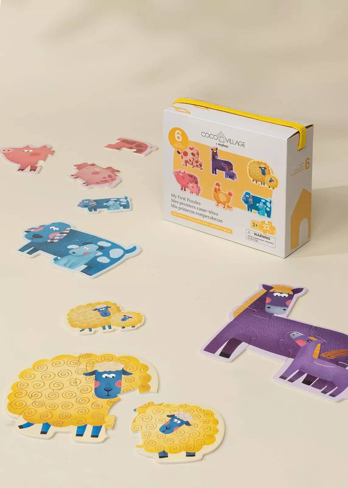 A children's animal matching game set with colorful animal cutout cards and its product box on a light beige background. The box reads 'COOL CLOVER KIDS' and shows animal illustrations.