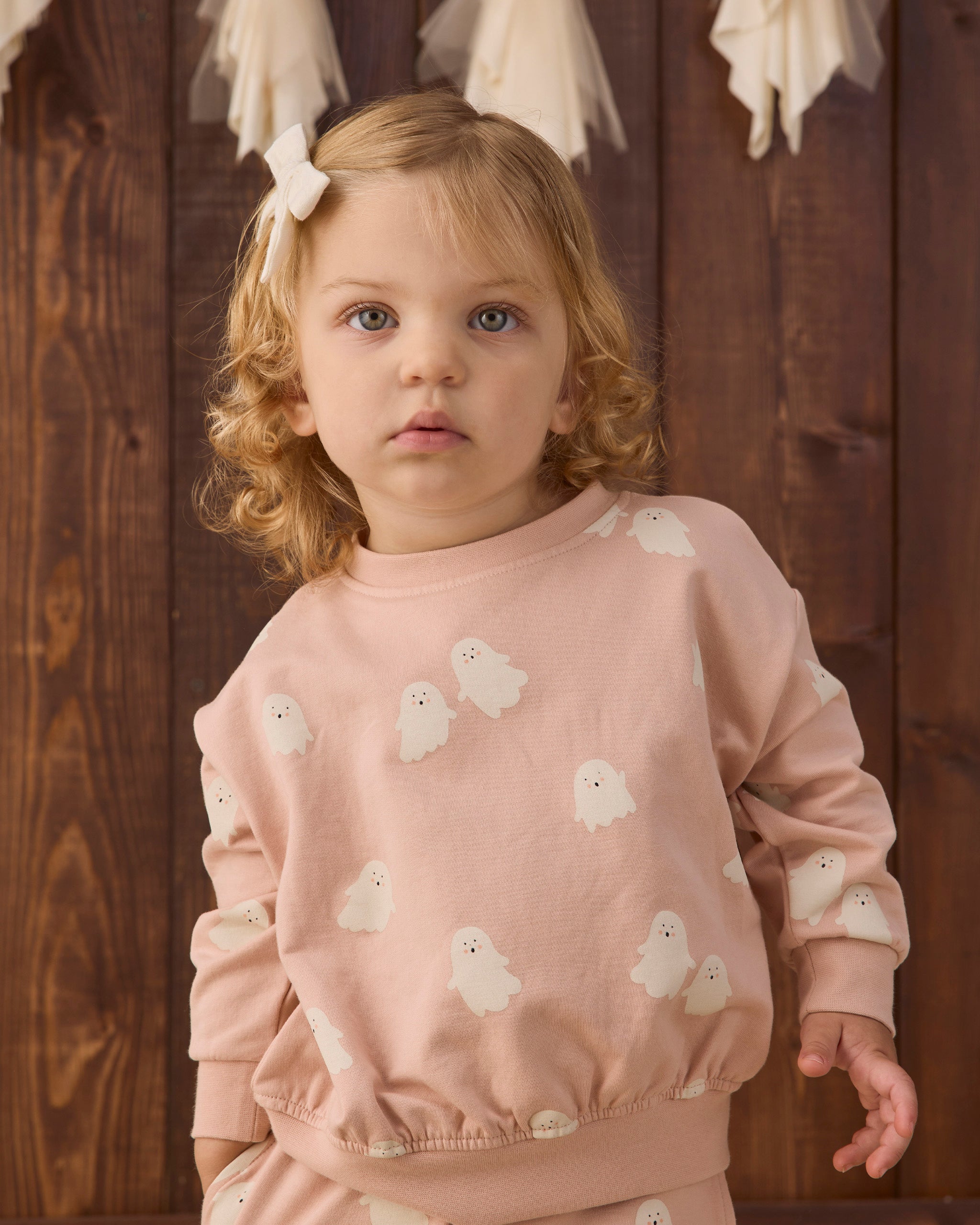 Girl in pink sweatshirt with ghosts on it