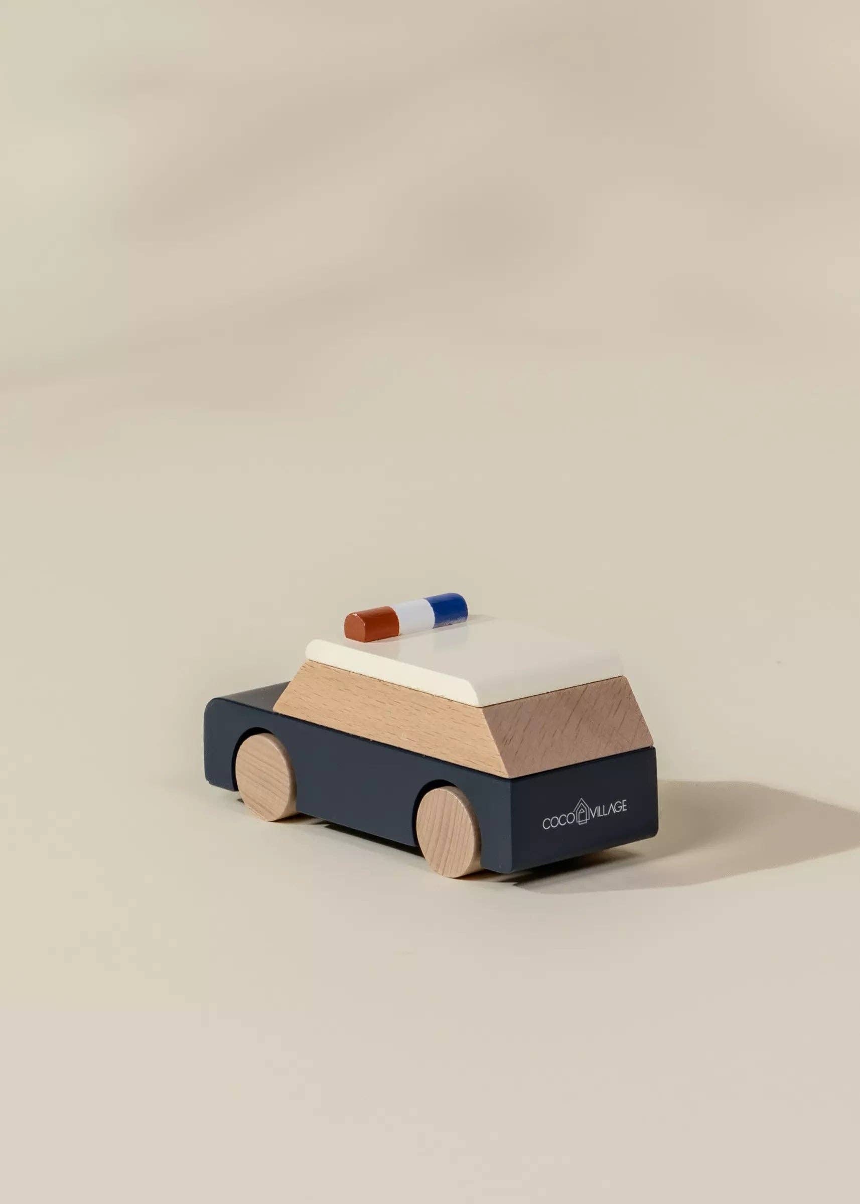Wooden toy car with a police light on a beige background