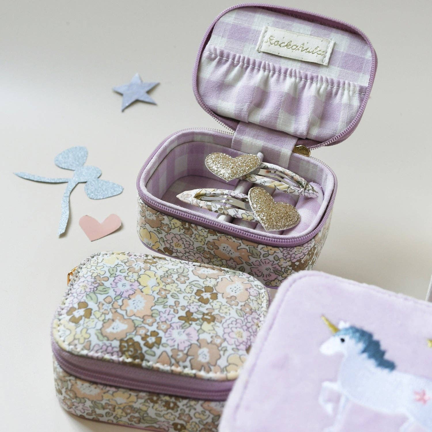 Children's jewelry set with floral case, heart-shaped earrings, and unicorn design on a light background