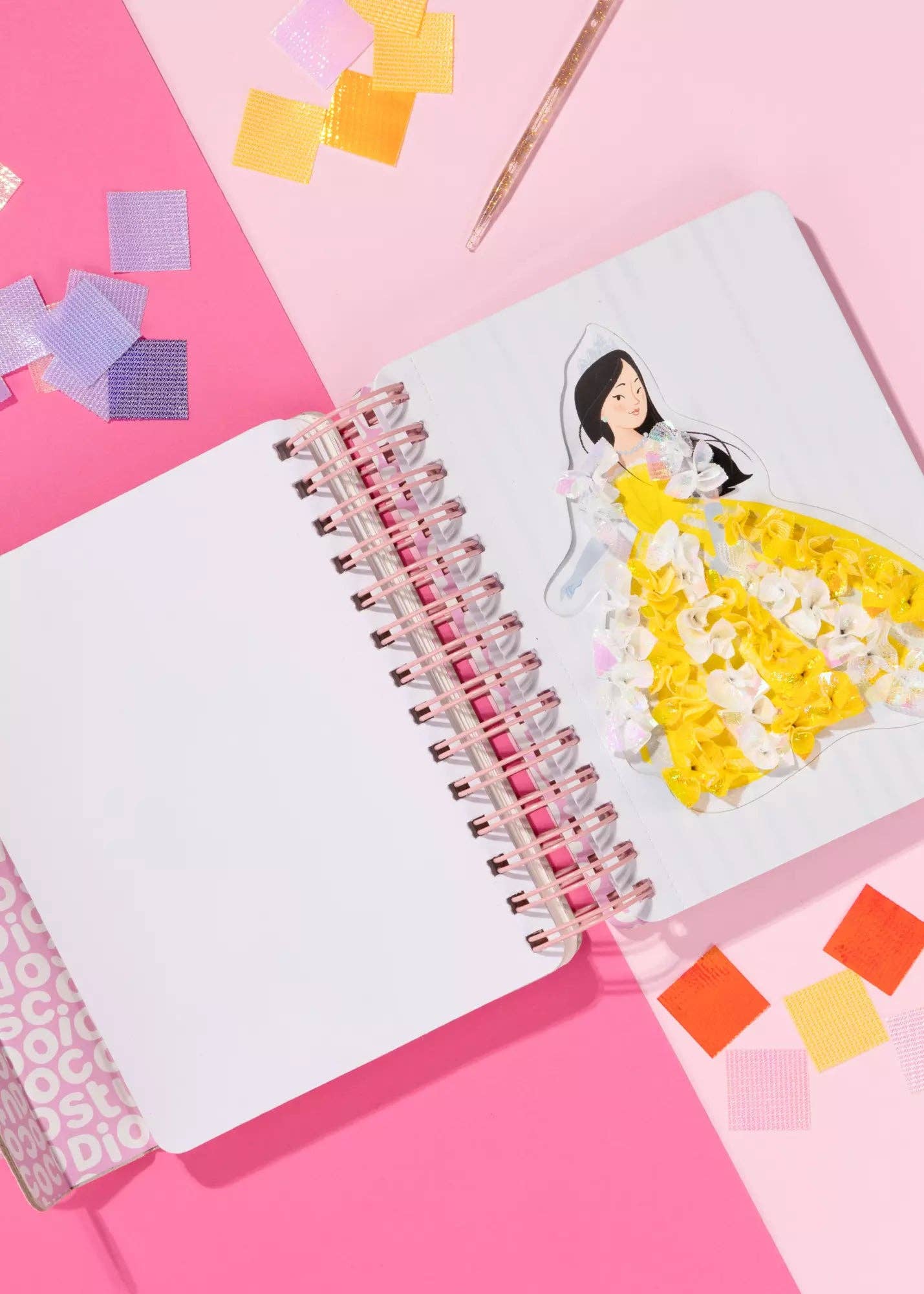 Notebook with a drawing of a princess in a yellow dress on a pink background with colorful square stickers.