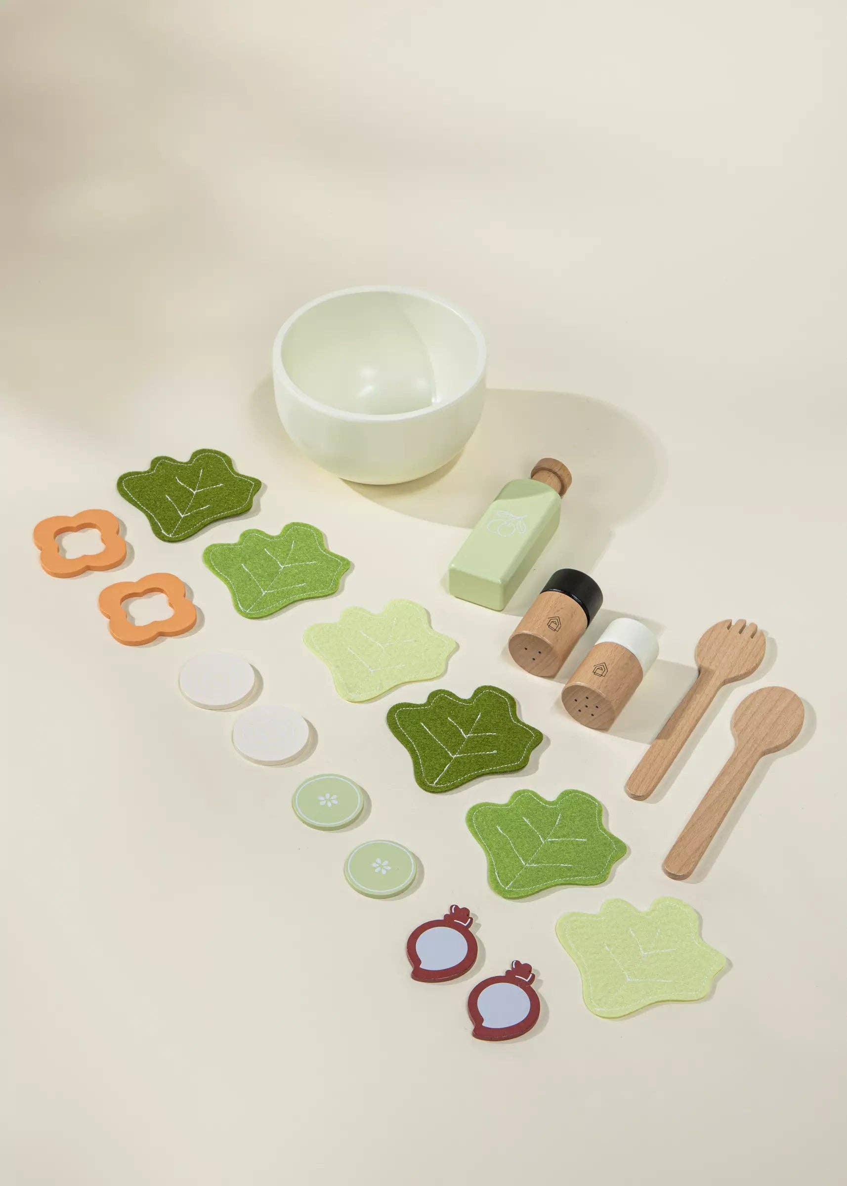 Set of wooden play food items including a bowl, bottles, and various shaped pieces on a light background