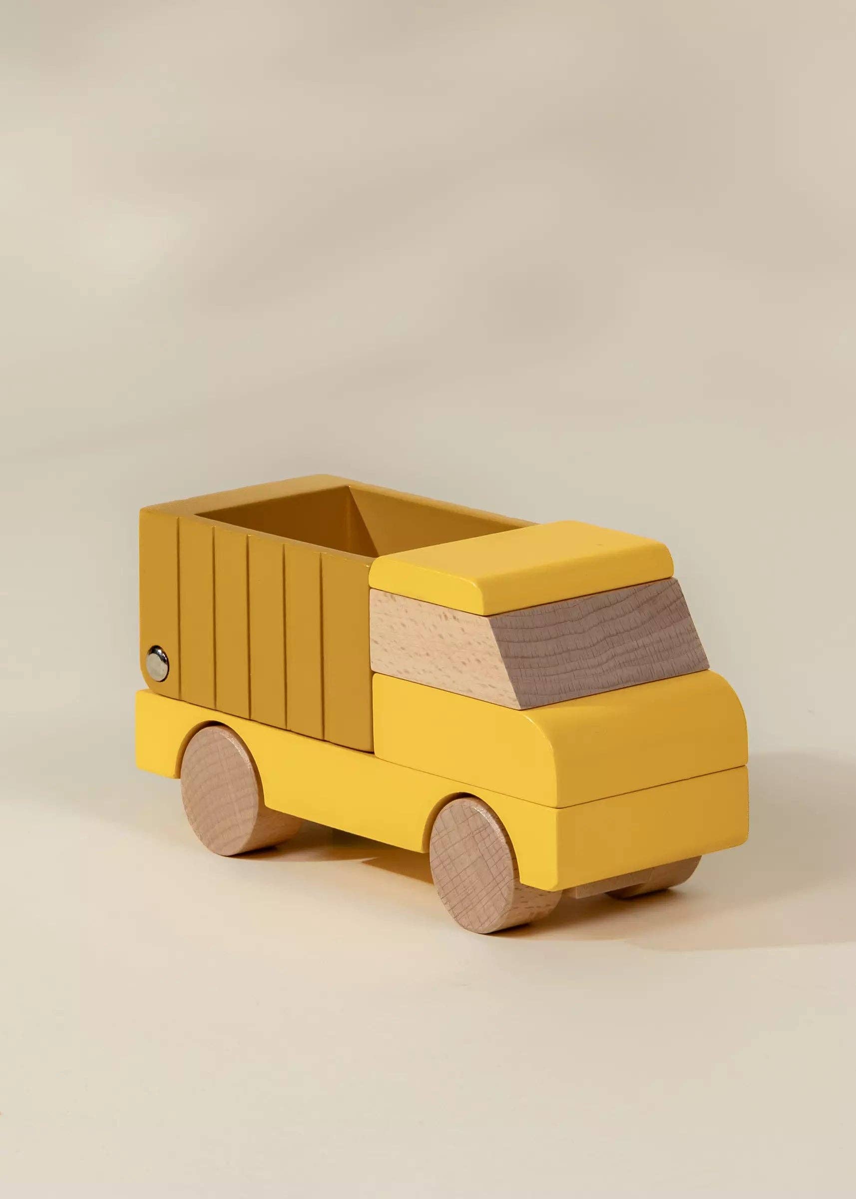 Yellow toy truck with wooden accents on a beige background